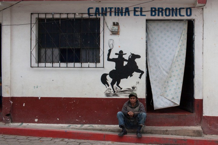 A man sits outside one of the many bars that have opened in San Marcos that cater to miners working in the Marlin Mine