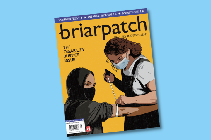 The cover of Briarpatch's Disability Justice Issue on a light blue background. On the cover, someone with light brown skin, who is wearing a mask and a black hoodie, is seated and looks ahead into the distance. On their right arm, just above the elbow, is a tourniquet. A person with light brown skin, curly brown hair, and a mask stands over them, inserting a needle into their arm.